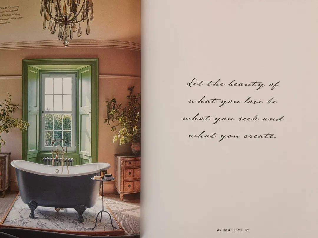 Roll-top bath beneath a green-framed window, opposite a handwritten quote