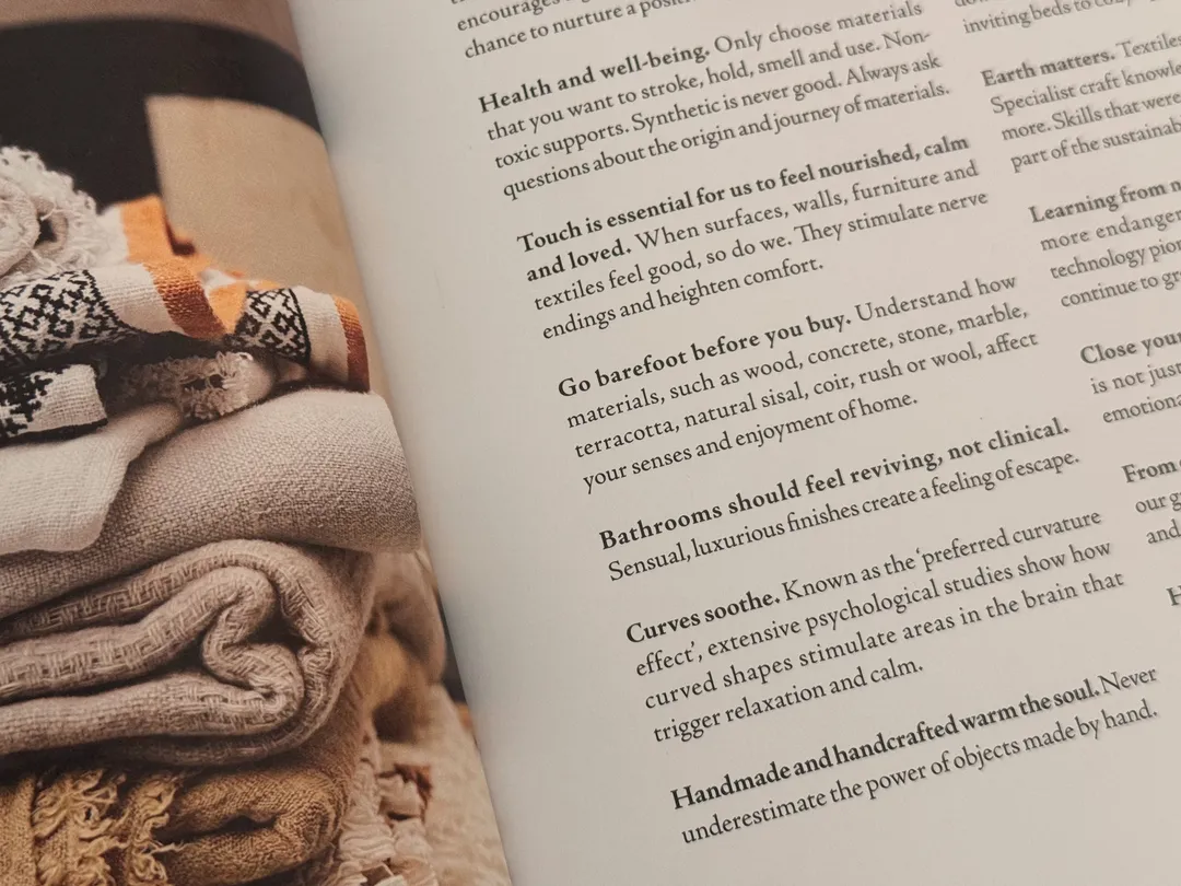 Stacked wool throws in warm tones beside text on comfort and texture