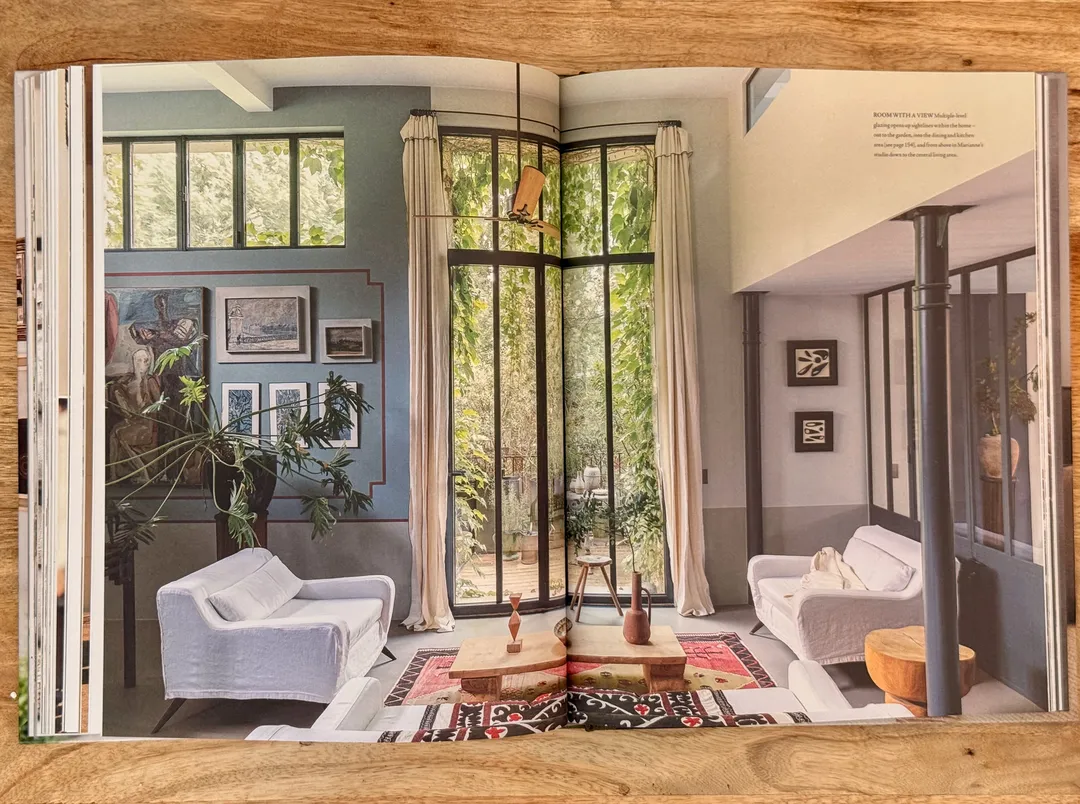 Light-filled sitting room with white sofas, tall steel windows and a patterned rug