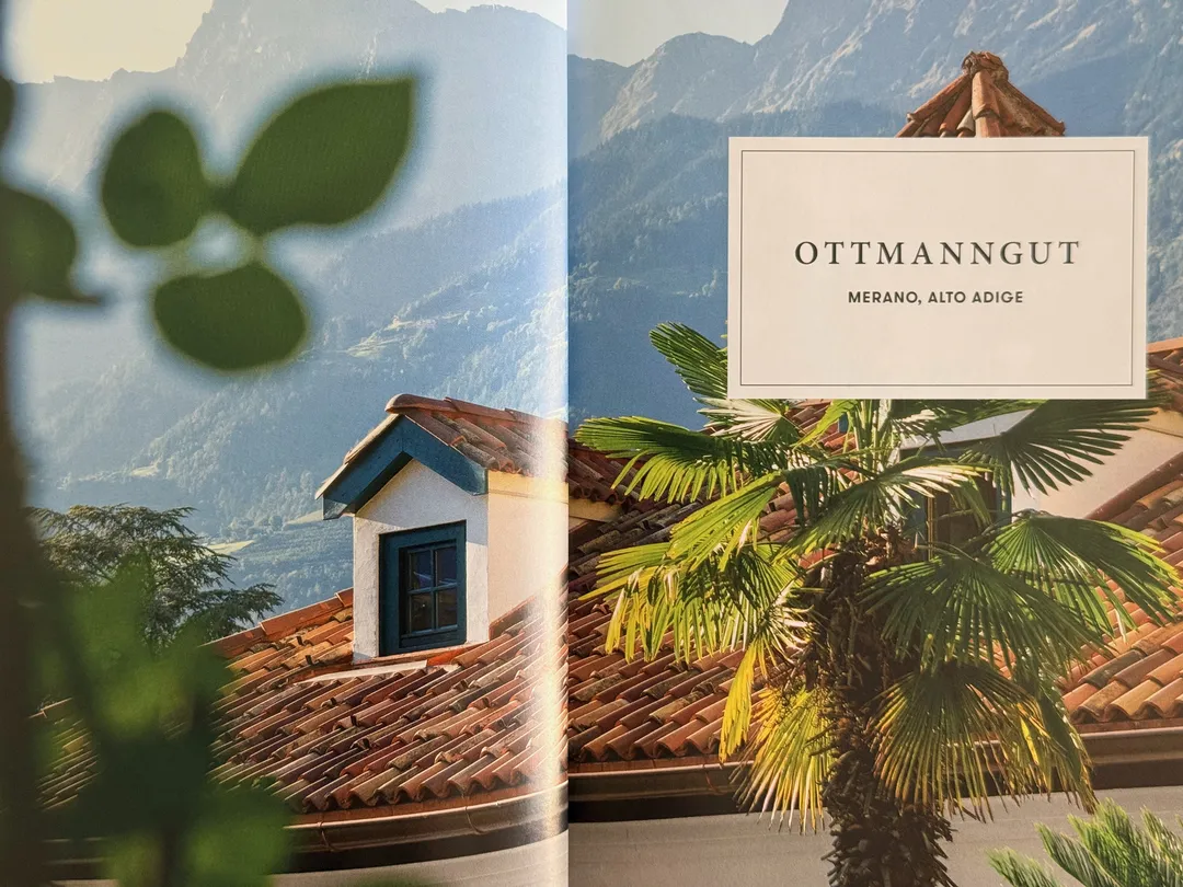 Ottmanngut hotel in Merano: terracotta roof and palm against the mountains, from Great Escapes Italy