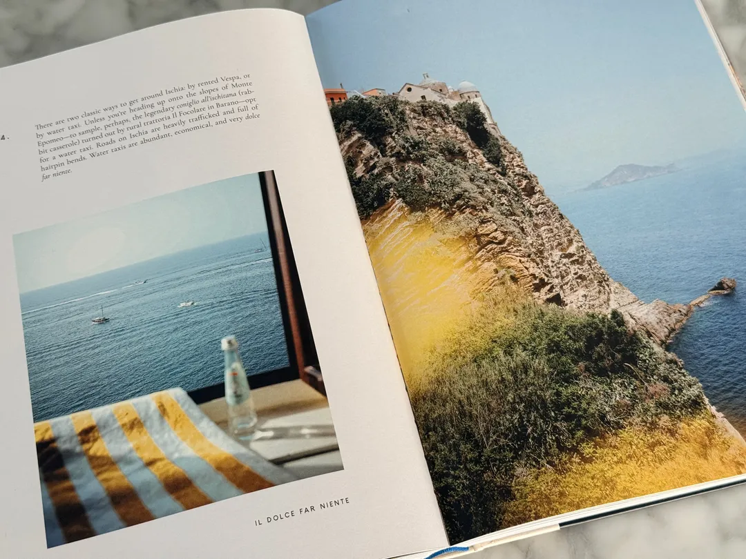Striped towel and water bottle on a seaside table, opposite a cliffside headland
