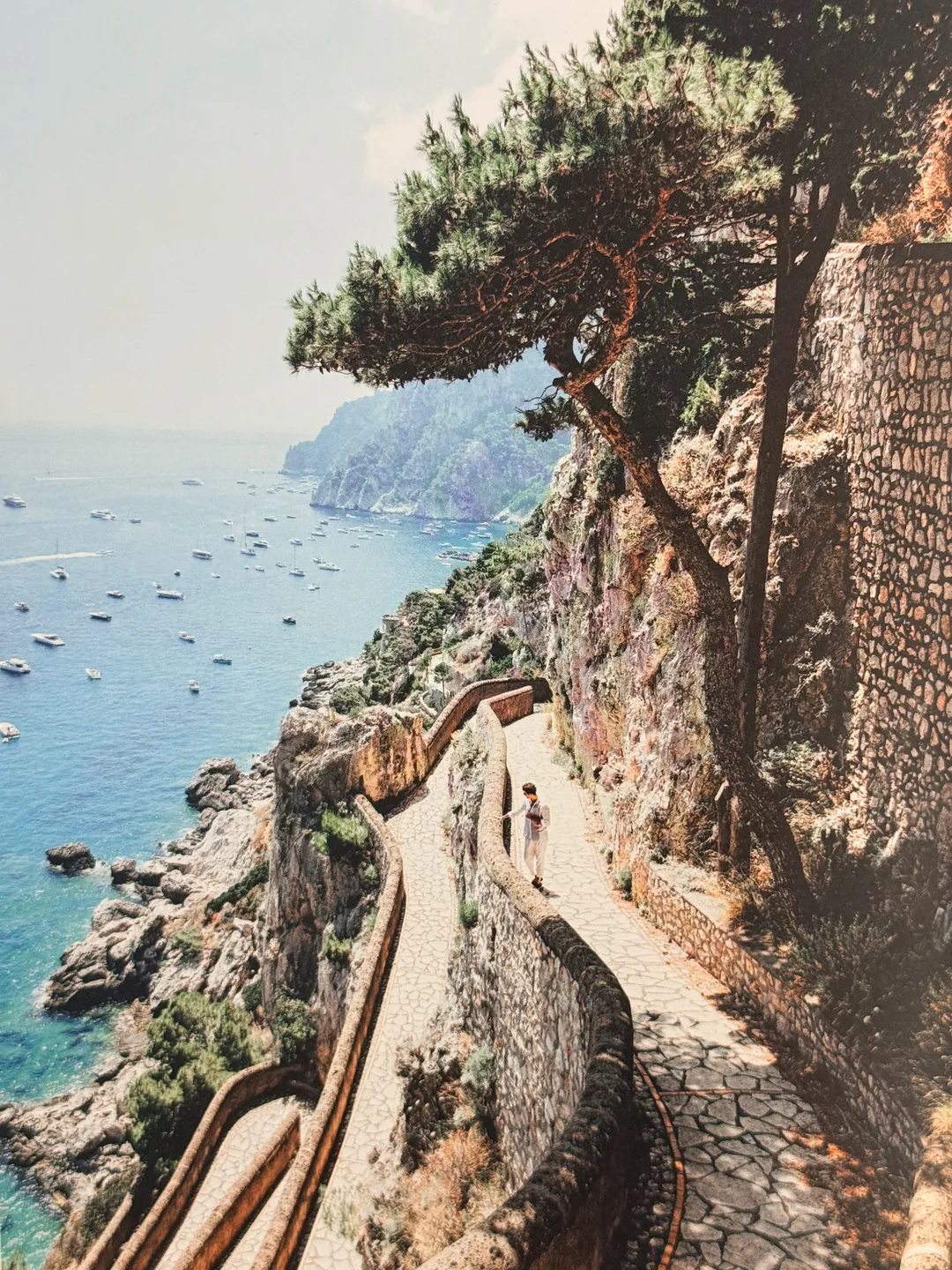 Cliffside path above a boat-dotted bay on Capri, from Il Dolce Far Niente by Lucy Laucht
