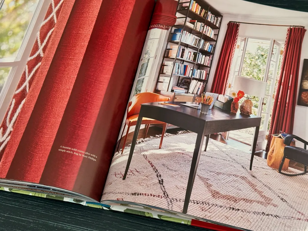 Study with red curtains, a writing desk and a Berber rug