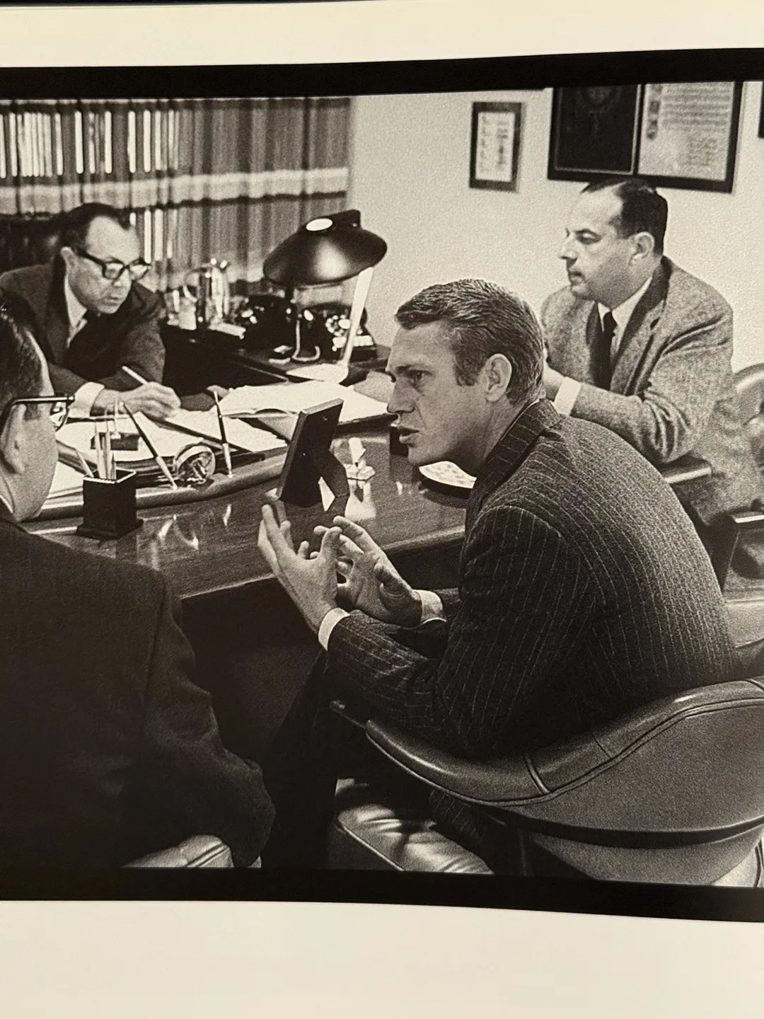 McQueen at a meeting table in an office