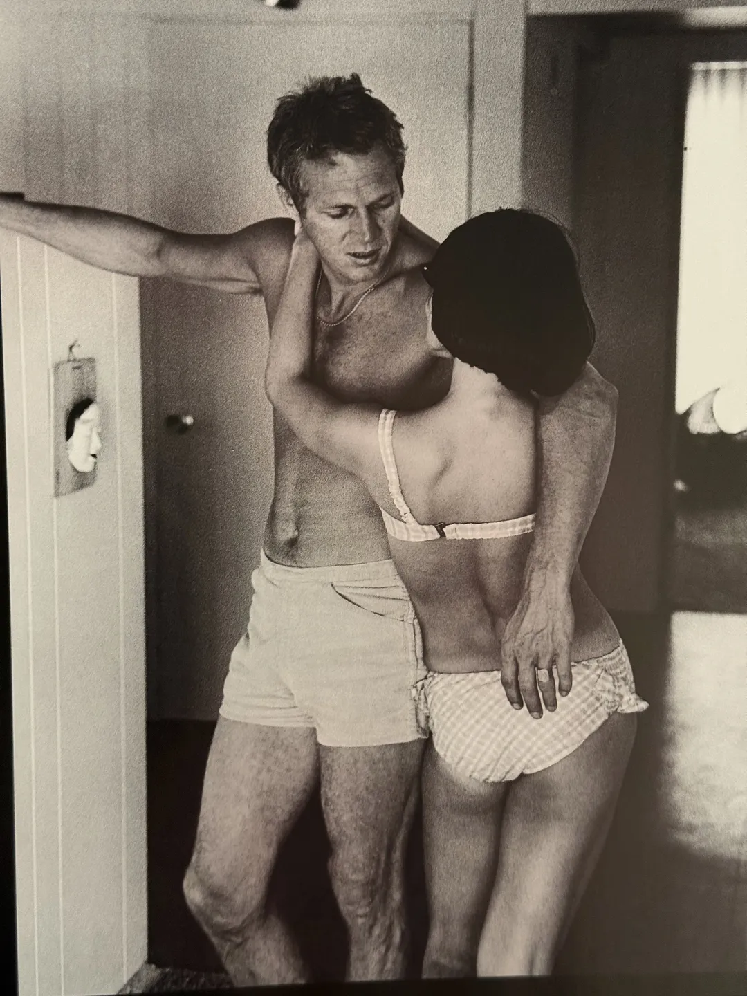 McQueen embracing a woman in a doorway
